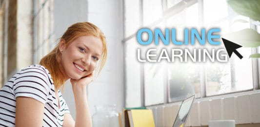 Smiling young woman studying at home an online course